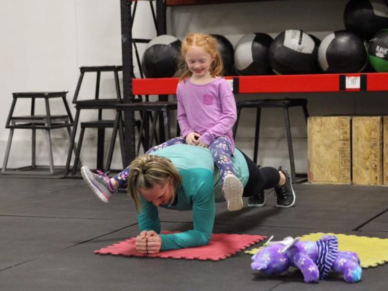 Mia helping Ellen out on her weighted planks.